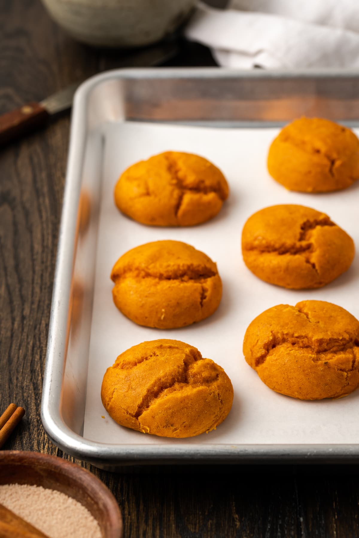 These soft and fluffy pumpkin cookies with cake mix are an easy fall dessert, made with only 2 ingredients and ready for the oven in minutes! Baked cake mix pumpkin cookies on a metal baking sheet.