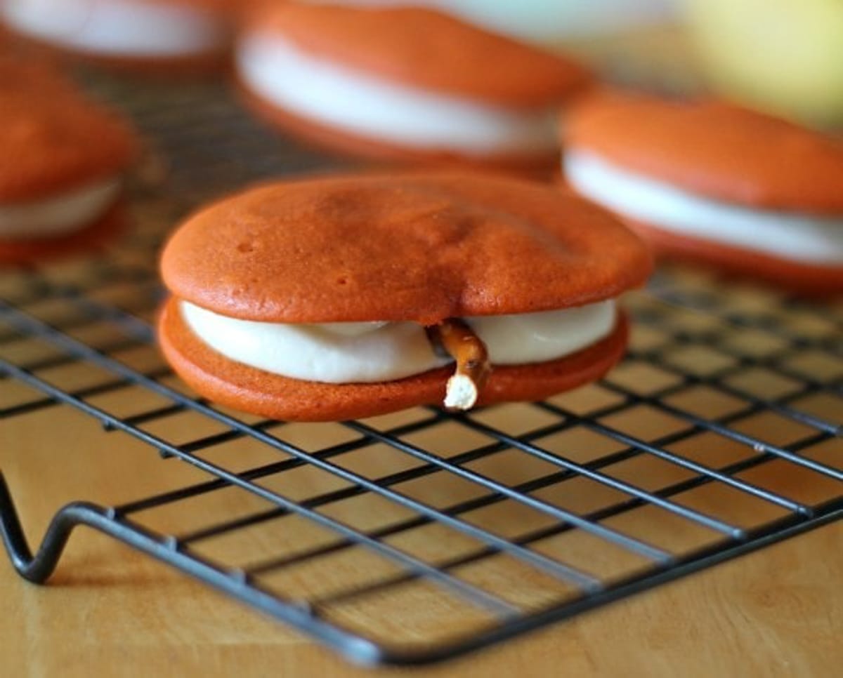 Pumpkin Whoopie Pie on a wire rack with a pretzel stem