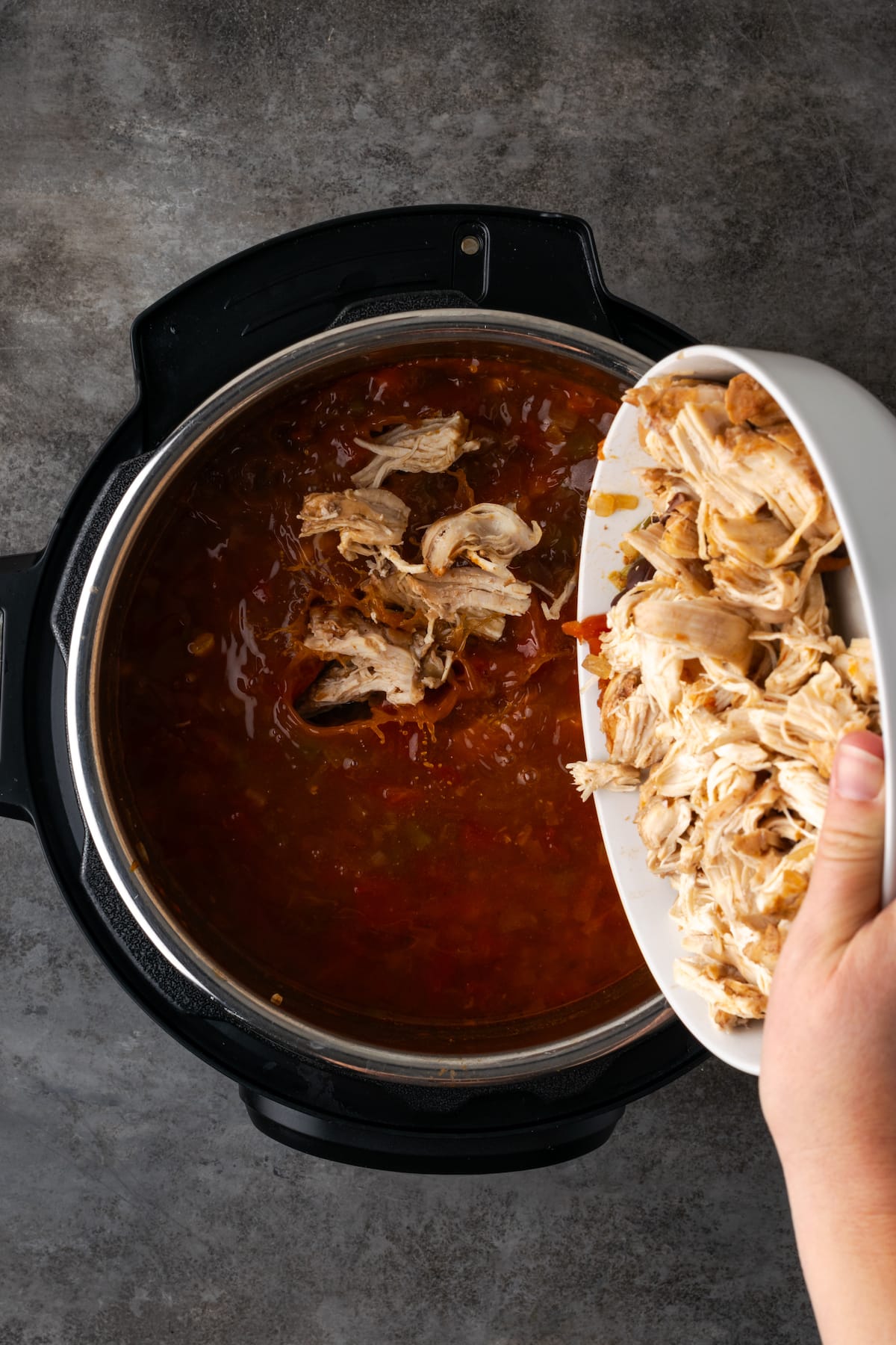 Smoky and flavorful Instant Pot chicken tortilla soup is a comforting one-pot meal that's easy to make any night of the week! Shredded chicken added back into the Instant Pot with the broth ingredients.