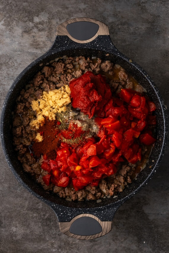 This easy unstuffed cabbage recipe is a savory one-pot meal made with juicy ground beef, pork, tangy fire-roasted tomatoes, and onions. Tomatoes, tomato paste, and seasonings added to browned ground beef in a skillet.
