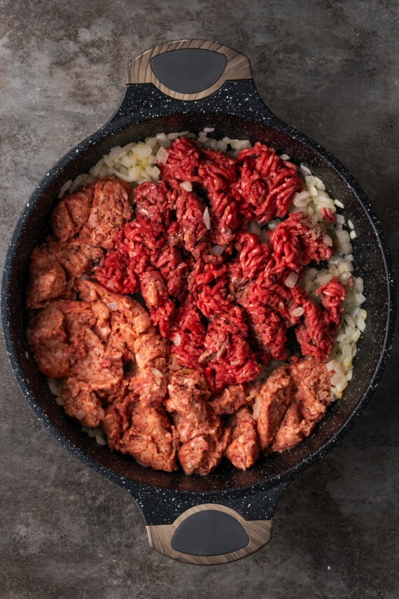 This easy unstuffed cabbage recipe is a savory one-pot meal made with juicy ground beef, pork, tangy fire-roasted tomatoes, and onions. Ground beef and pork sausage added to diced onion in a skillet.