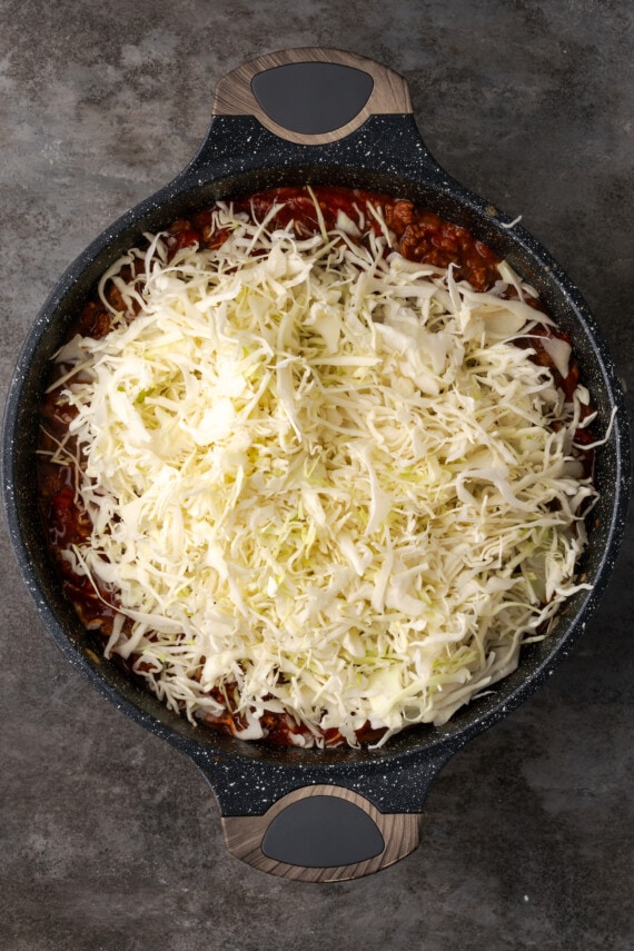 This easy unstuffed cabbage recipe is a savory one-pot meal made with juicy ground beef, pork, tangy fire-roasted tomatoes, and onions. Shredded cabbage added to a skillet with ground beef and tomatoes.