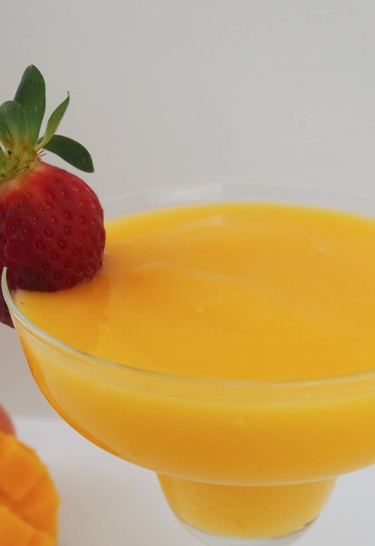 Mango Daiquiri in a cocktail glass and with a strawberry on the rim.