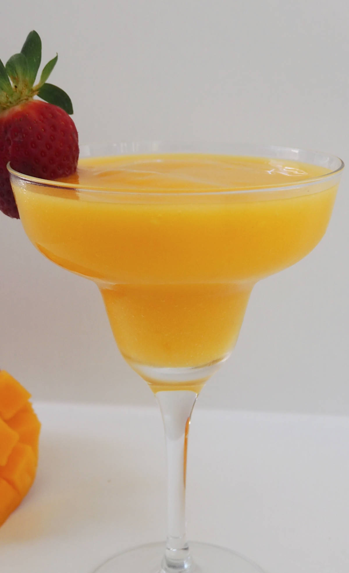 Mango Daiquiri in a cocktail glass and with a strawberry on the rim.