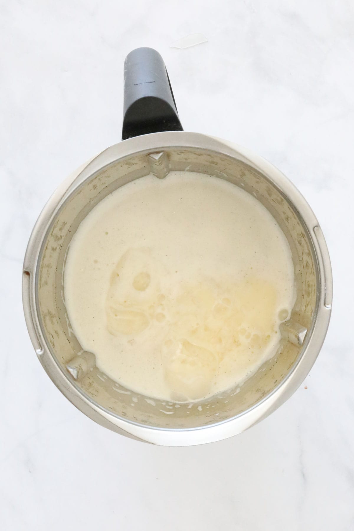 Gelatine leaves being added to cream in a Thermomix.
