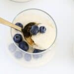 An overhead shot of a gold spoon in a creamy berry dessert.