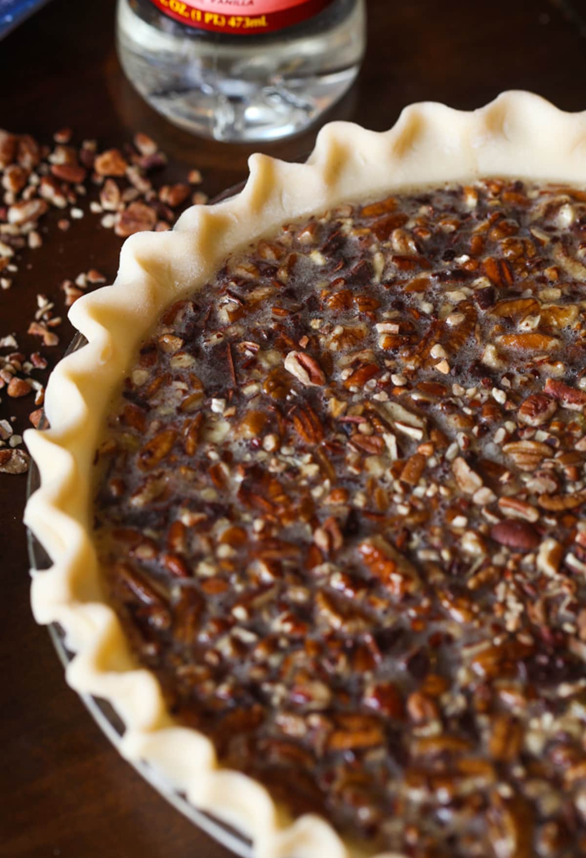 My EASY Chocolate Pecan Pie Recipe is a classic pecan pie recipe made even more delicious with melted chocolate, which turns the filling into a rich pudding-like texture loaded with pecans! An unbaked chocolate pecan pie in a pie shell before putting it in the oven.