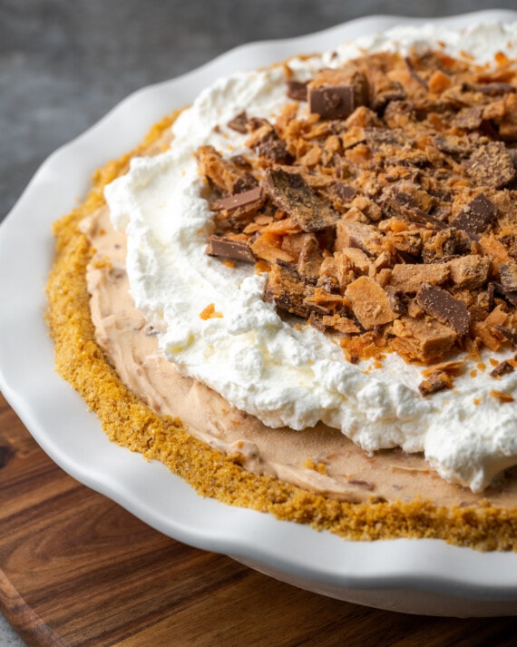 Butterfinger pie garnished with whipped cream and chopped Butterfinger candy bars.
