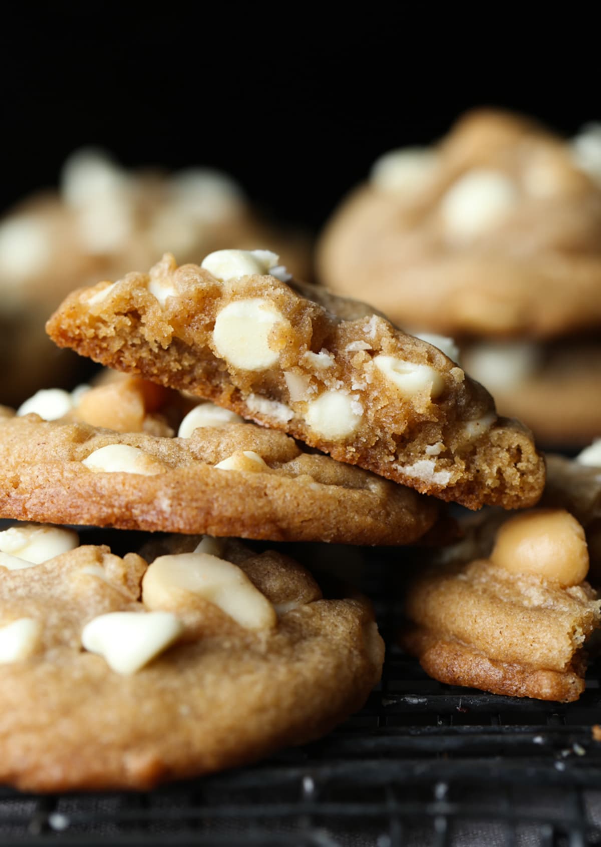 These white chocolate macadamia nut cookies are a classic. They have buttery, crisp edges with chewy centers loaded with creamy white chocolate and salty macadamia nuts. White Chocolate Macadamia Nut Cookies stacked and broken in half showing the gooey centers
