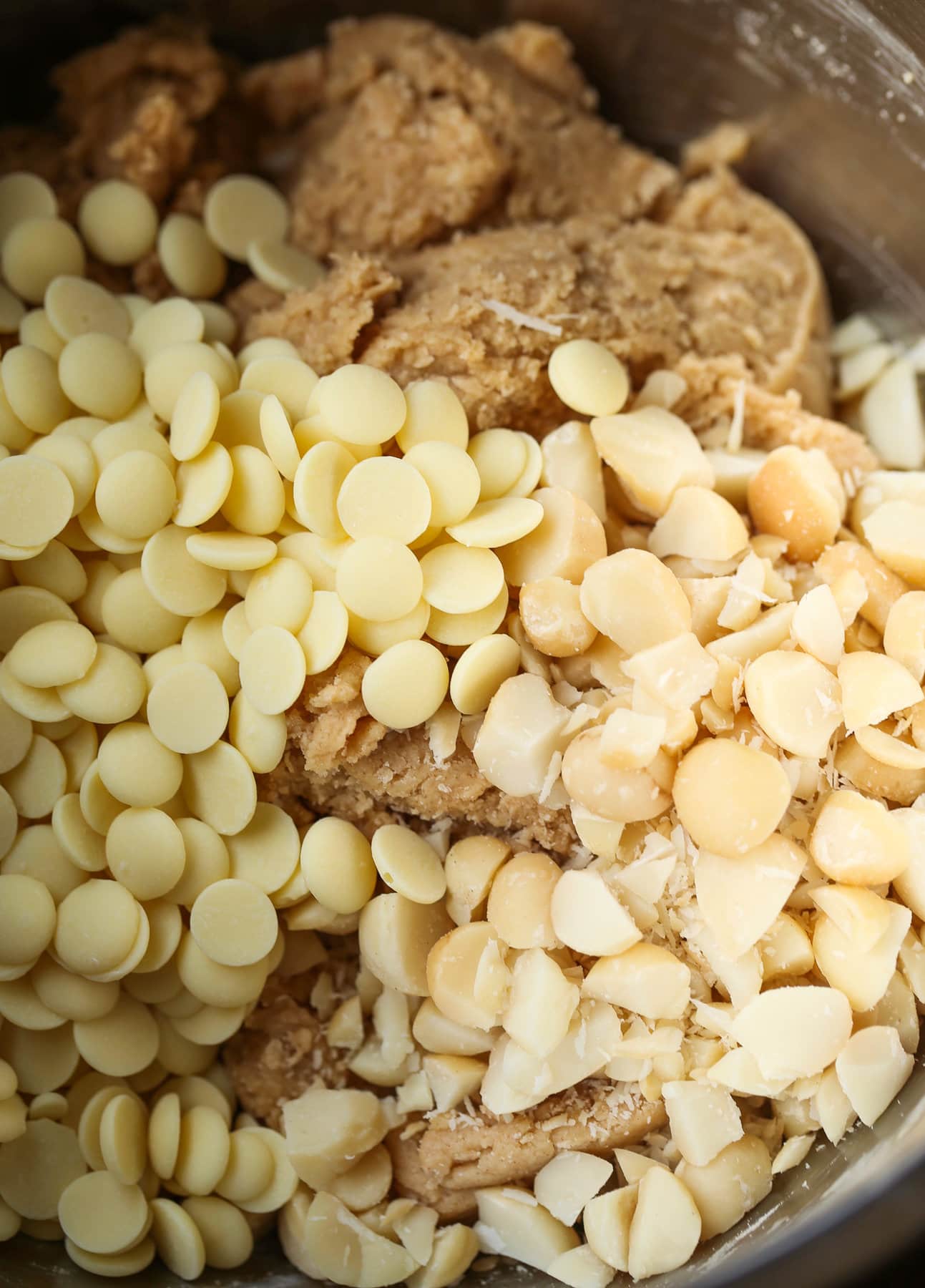These white chocolate macadamia nut cookies are a classic. They have buttery, crisp edges with chewy centers loaded with creamy white chocolate and salty macadamia nuts. Mixing white chocolate chips into cookie batter in a mixing bowl