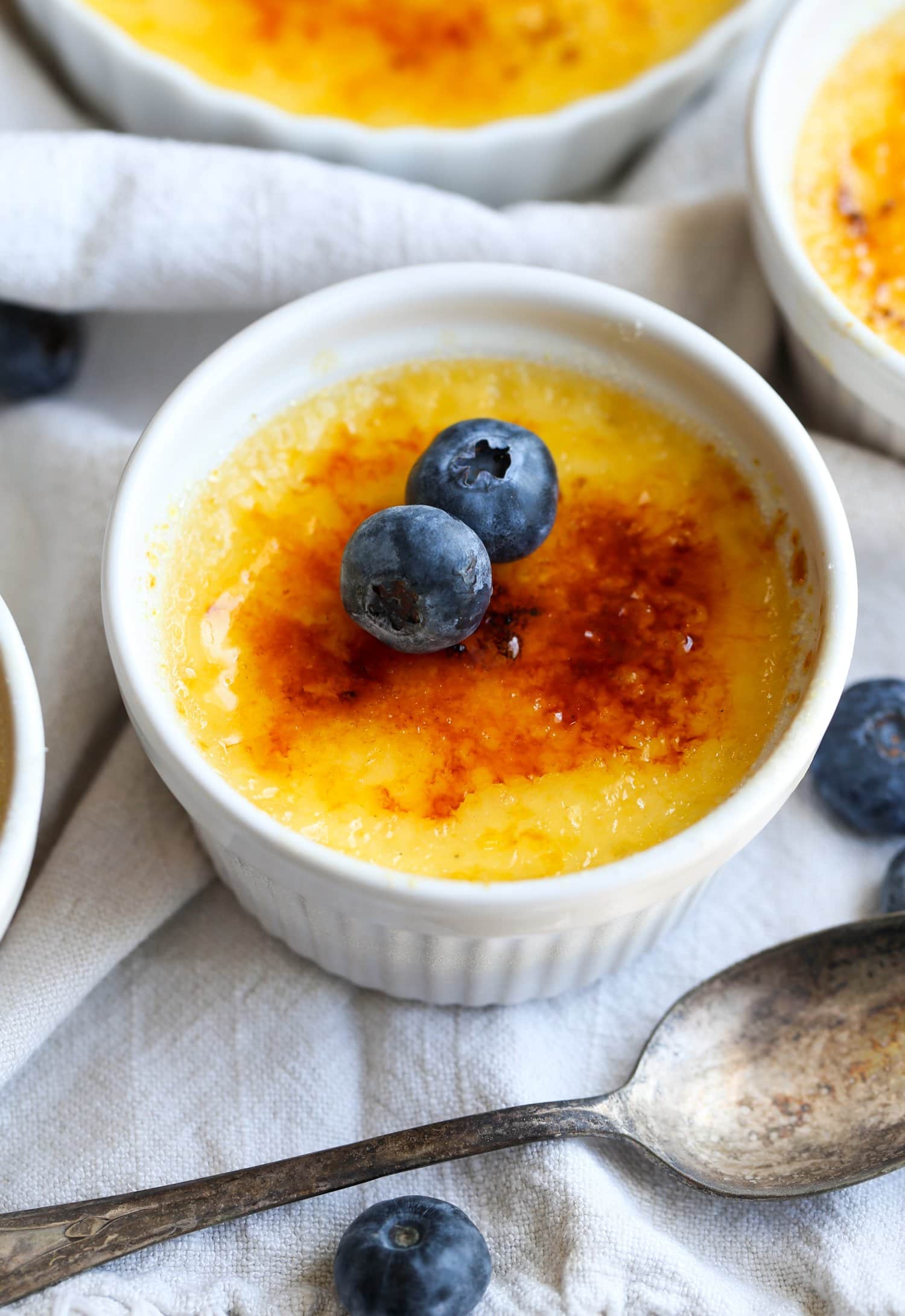 A ramekin of Creme Brûlée topped with blueberries