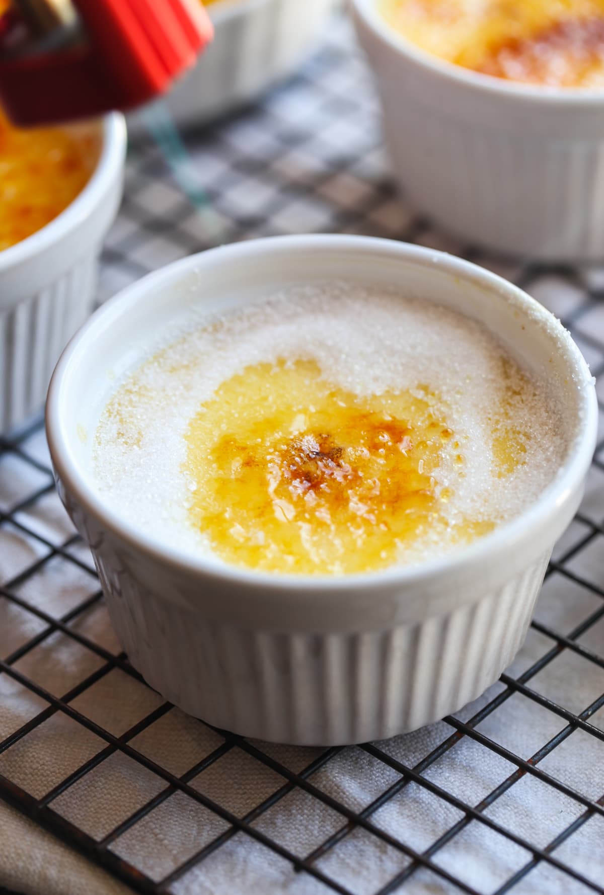 Torching sugar on top of custard baked in a white ramekin