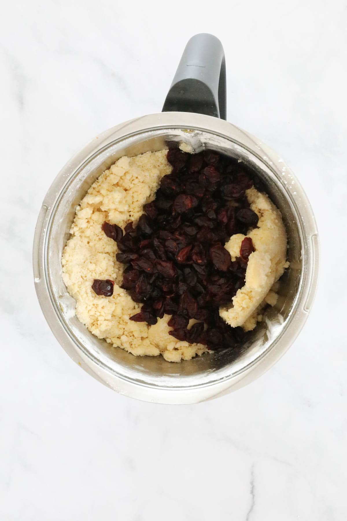 Dried cranberries on top of shortbread dough.