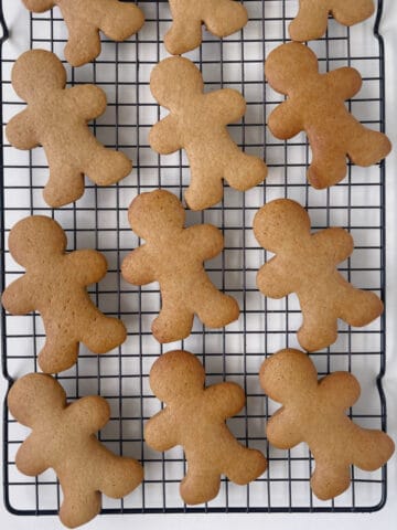 Baked gingerbread biscuits on a wire rack.