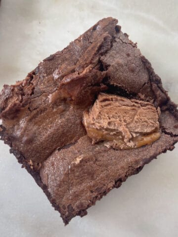 Overhead view of a piece of Mars Bar Brownie sitting on a stone serving tray.