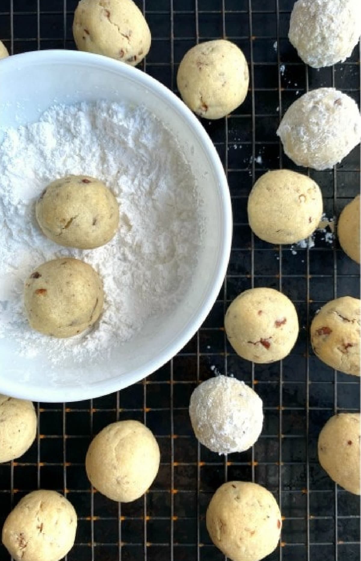 Russian tea cakes are rich and buttery shortbread cookies filled with crunchy pecans, rolled in powdered sugar to look like frosty snowballs. Every bite melts away in your mouth! Rolling baked Russian Tea Cakes in Powdered Sugar