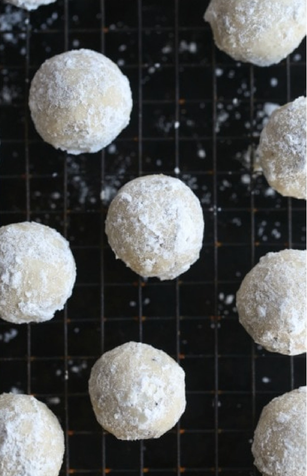 Russian tea cakes are rich and buttery shortbread cookies filled with crunchy pecans, rolled in powdered sugar to look like frosty snowballs. Every bite melts away in your mouth! Powdered Sugar Coated Snowball Cookies on a wire cooling rack