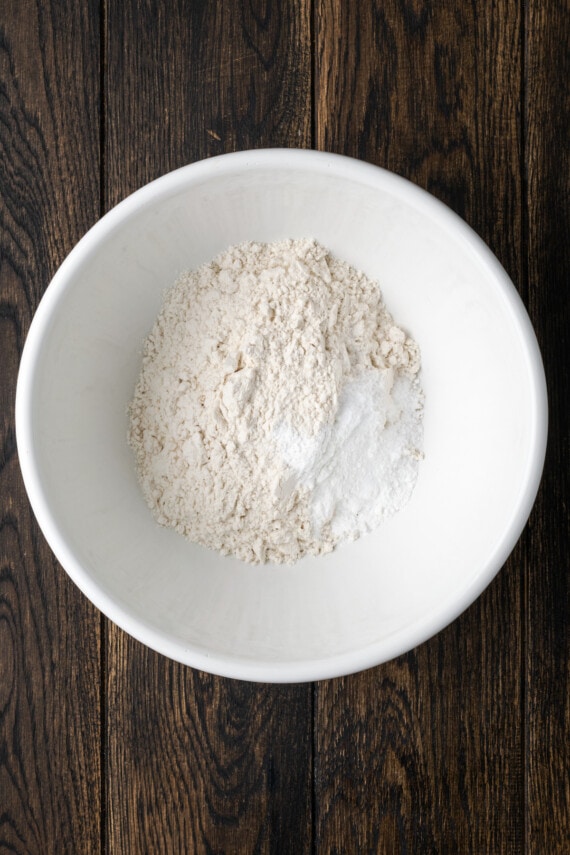 Dry cookie dough ingredients combined in a white bowl.