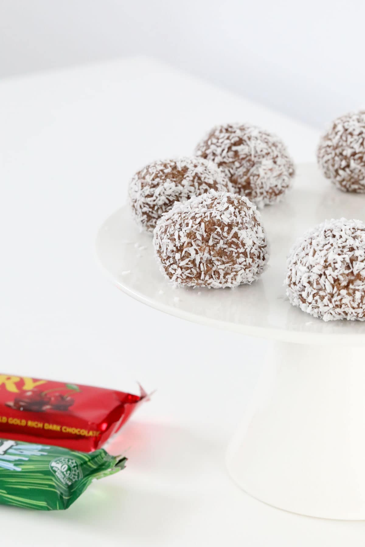 Cherry ripe and peppermint crisp balls on a cake stand.