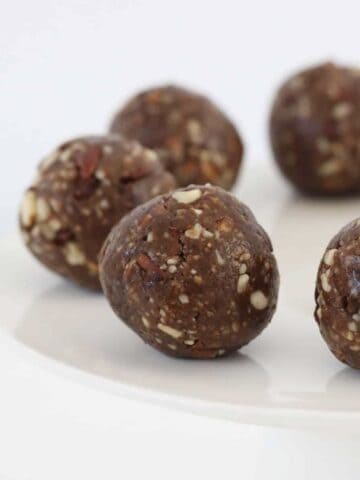 Round bliss balls on a cake stand.