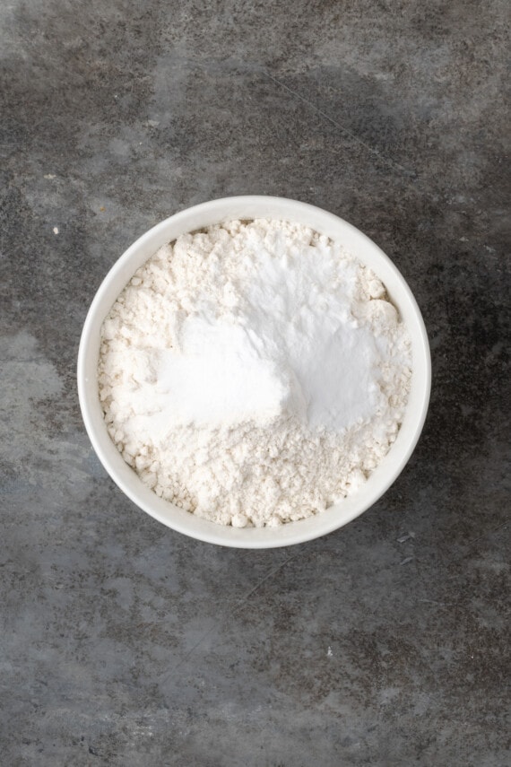 Dry cookie dough ingredients combined in a white bowl.