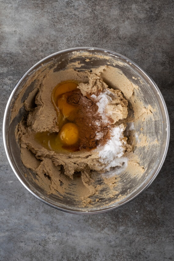 Soft and chewy oatmeal butterscotch cookies are rich and buttery, filled with tender oats, butterscotch morsels, and sweet cinnamon spice. Eggs added to a metal mixing bowl with creamed butter and sugar.