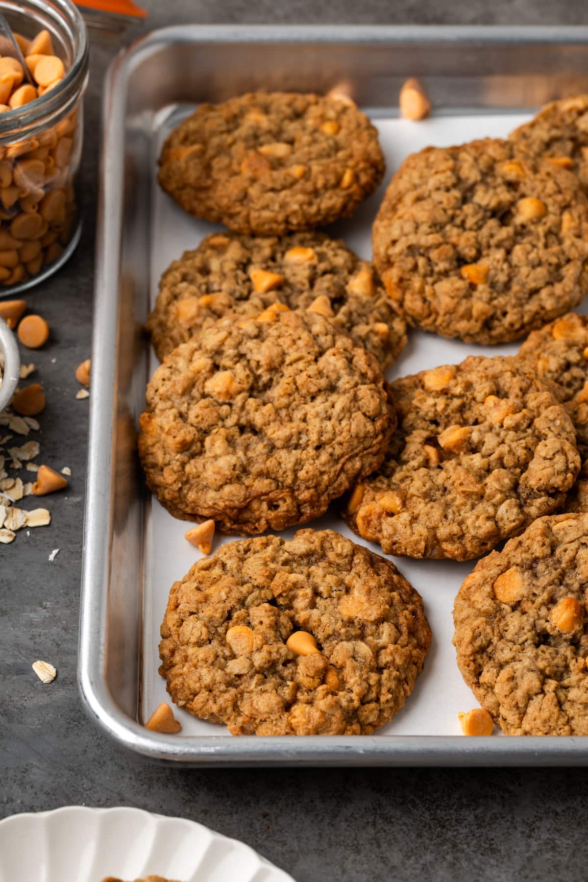 Soft and chewy oatmeal butterscotch cookies are rich and buttery, filled with tender oats, butterscotch morsels, and sweet cinnamon spice. Assorted oatmeal butterscotch cookies on a baking sheet.