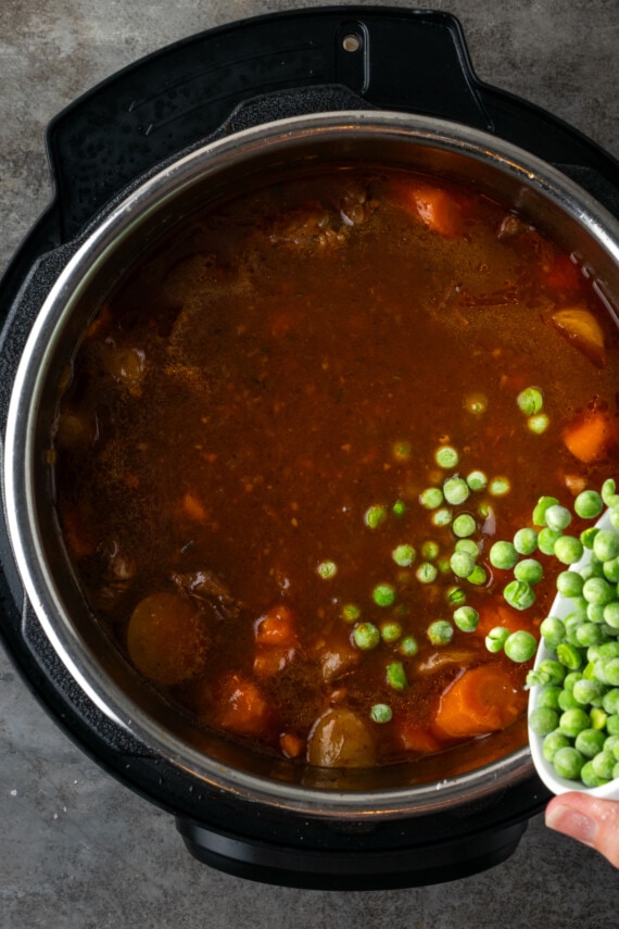 Frozen peas added to beef stew inside the instant pot.