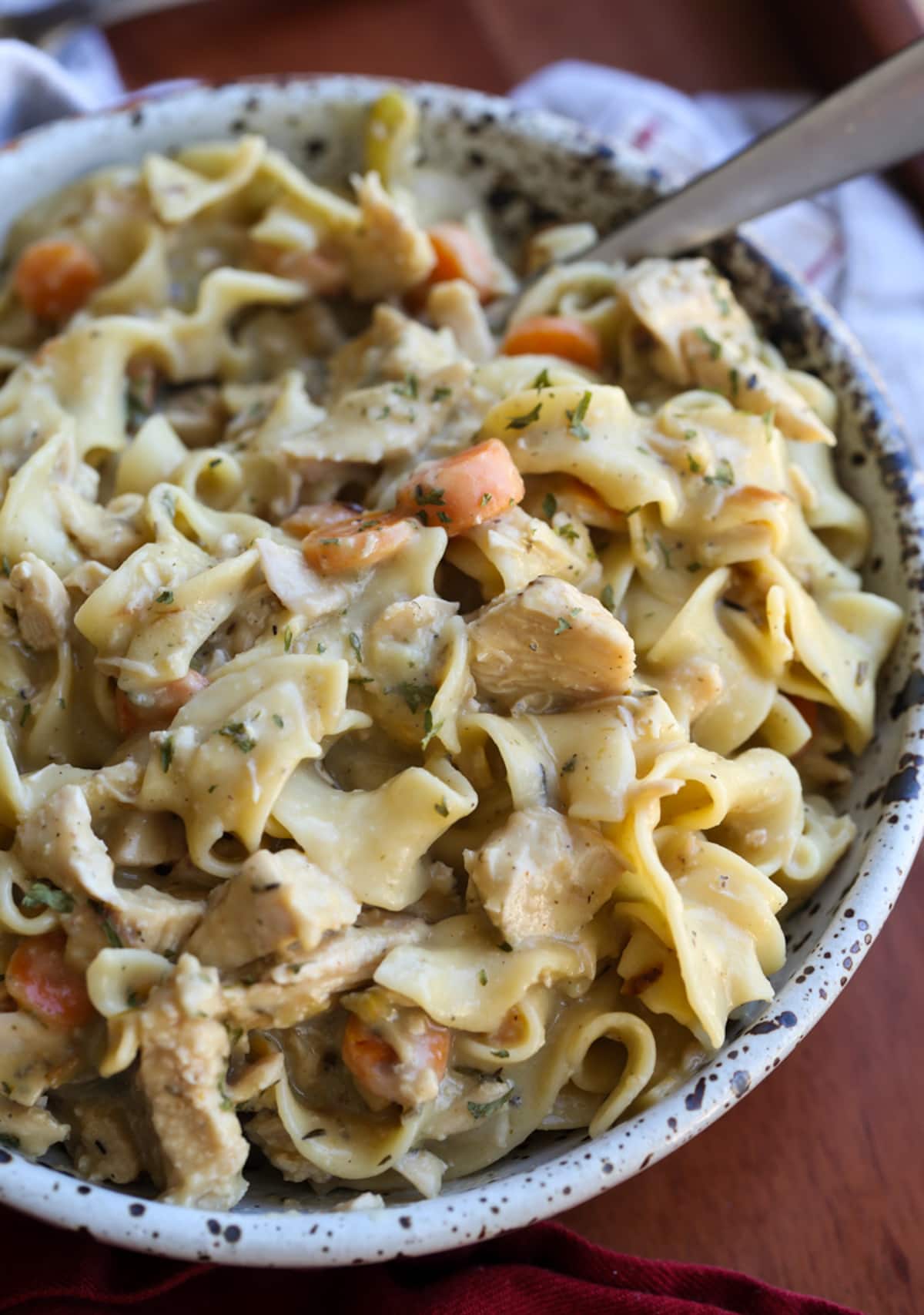 Serving chicken and noodles in a ceramic bowl.