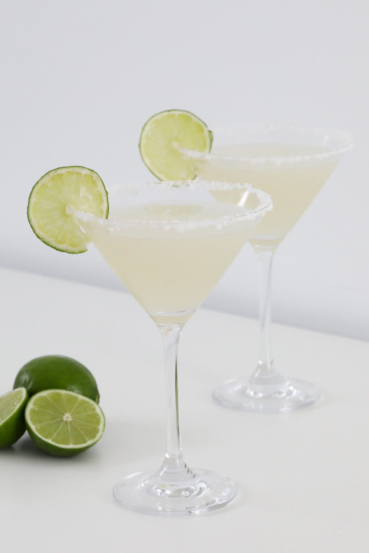 Two martini glasses filled with margaritas.