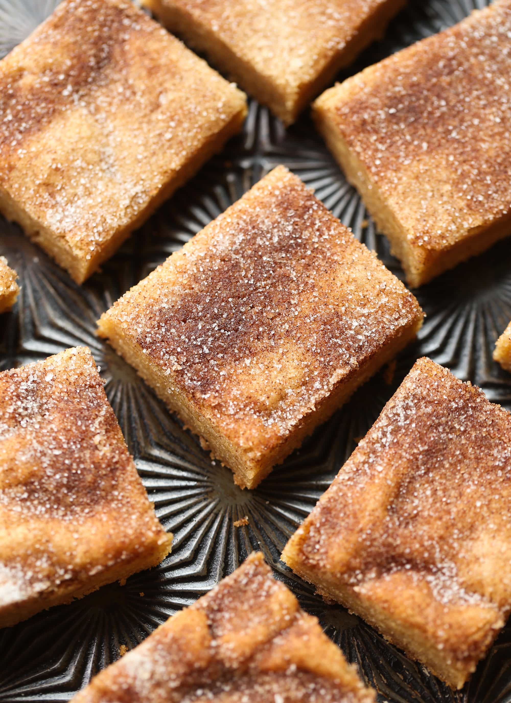 Buttery, chewy cookie bars that taste just like a churro! Cookie bars made with browned butter and topped with cinnamon sugar cut into squares on a baking sheet