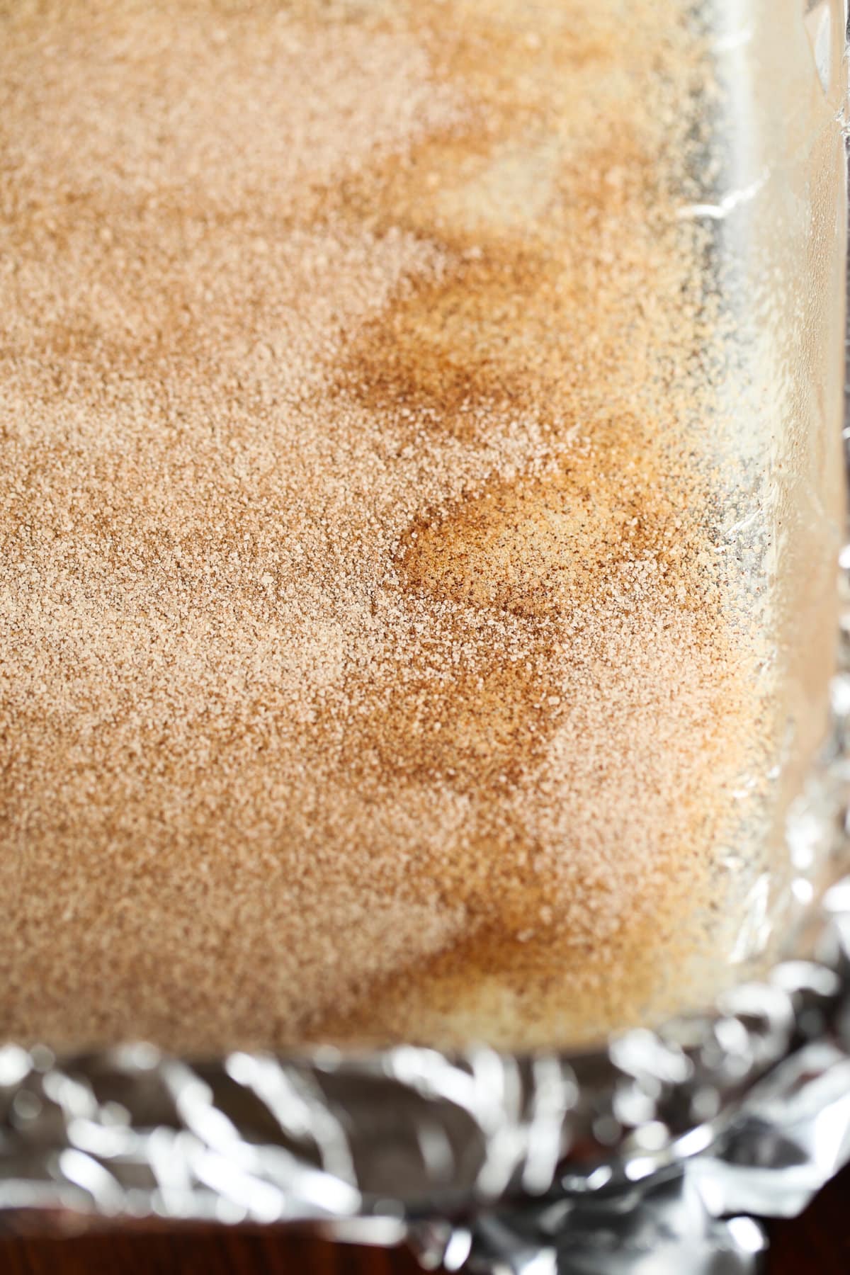 Buttery, chewy cookie bars that taste just like a churro! A 9x13 baking dish with cinnamon sugar coating the bottom before adding cokie dough on top.