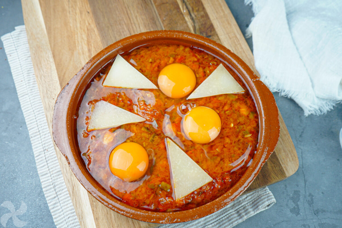 Colocamos el huevo y las cuñas de queso sobre el pisto