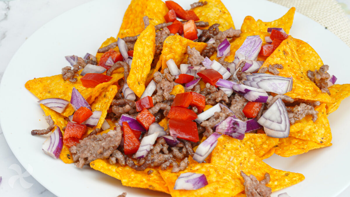 Echamos los ingredientes por encima de los nachos.