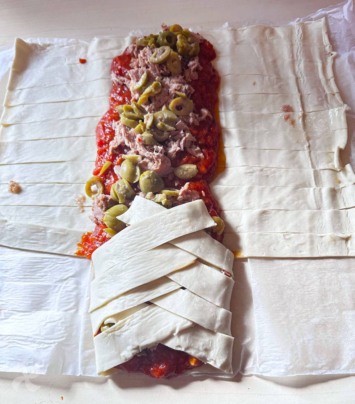 Hojaldre trenzado relleno de atún con tomate y aceitunas