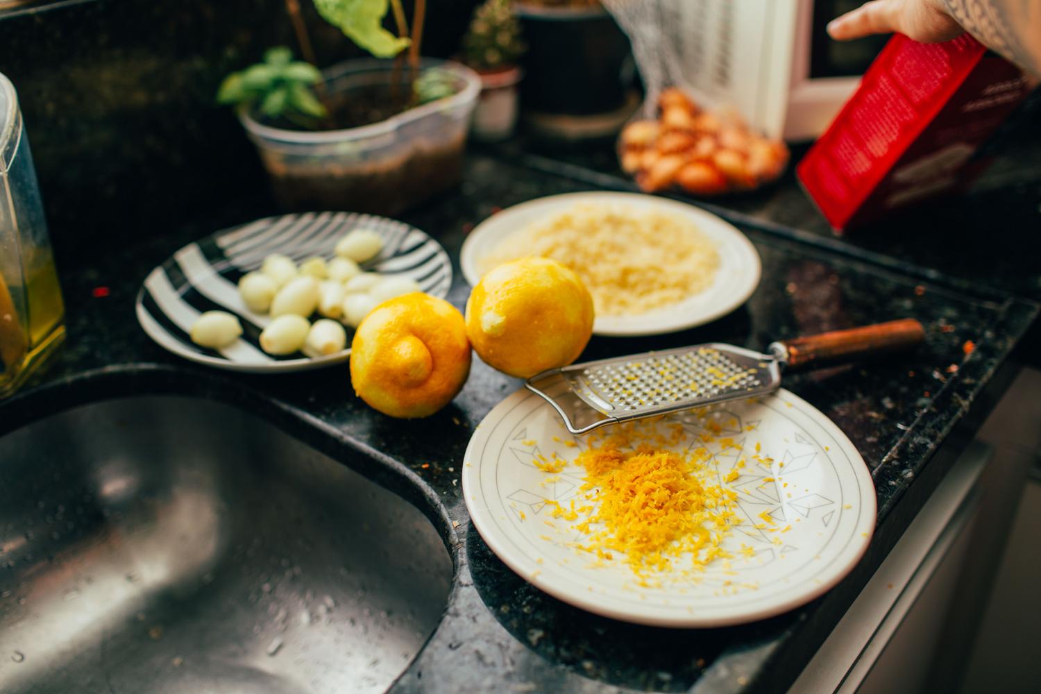 Preparación de ralladura de limón fresco en la cocina, ideal para el azúcar aromatizado cítrico.