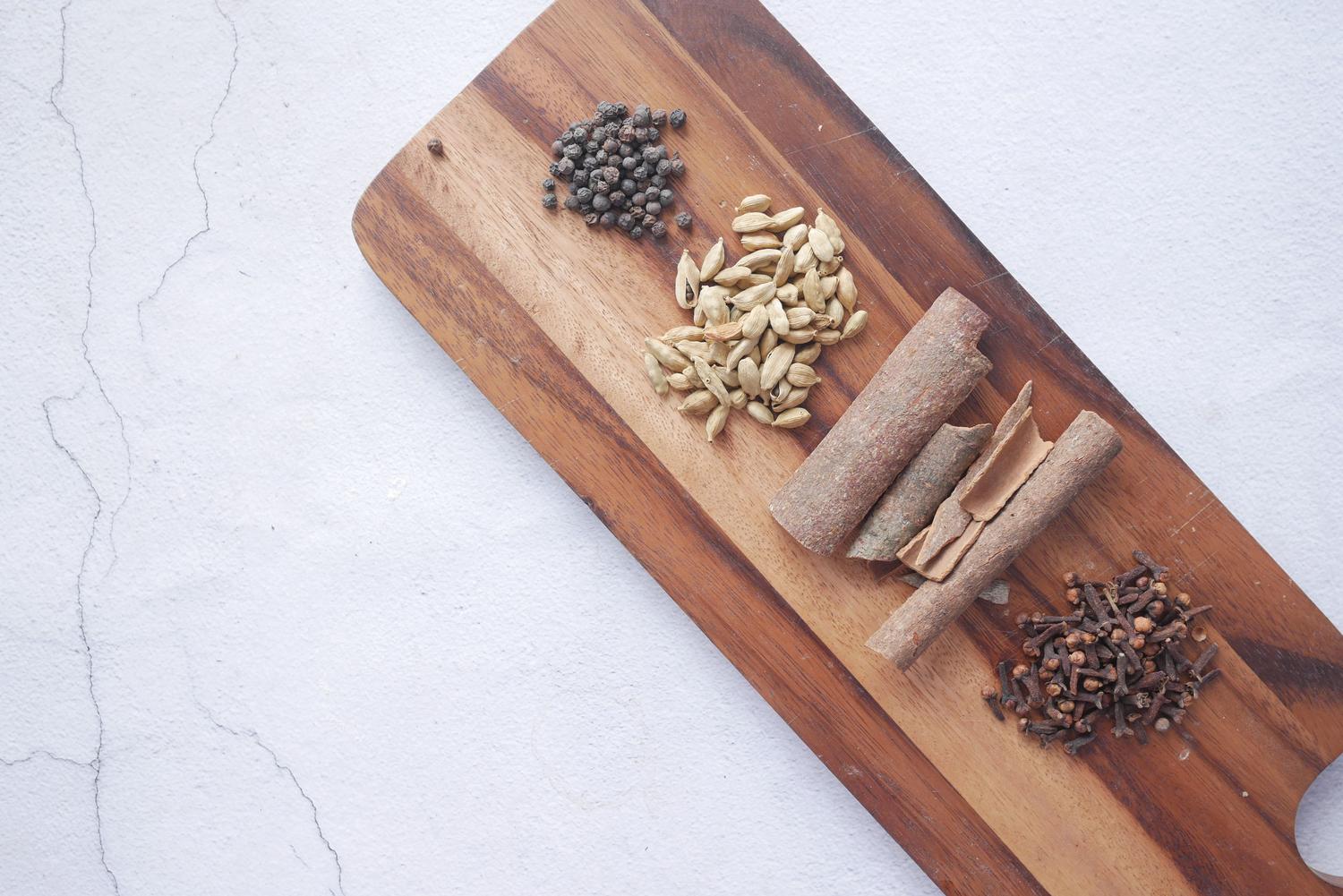 Canela en rama y otras especias aromáticas sobre una tabla de madera para ilustrar los azúcares especiados.
