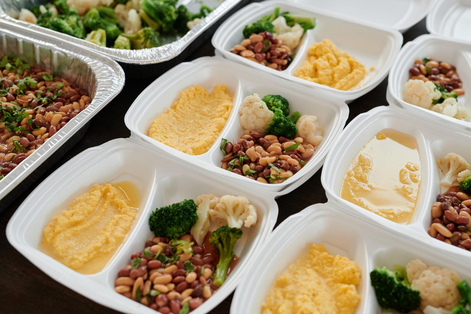 Variedad de recipientes con comidas preparadas, incluyendo brócoli y purés Variedad de recipientes con comidas preparadas, incluyendo brócoli y purés