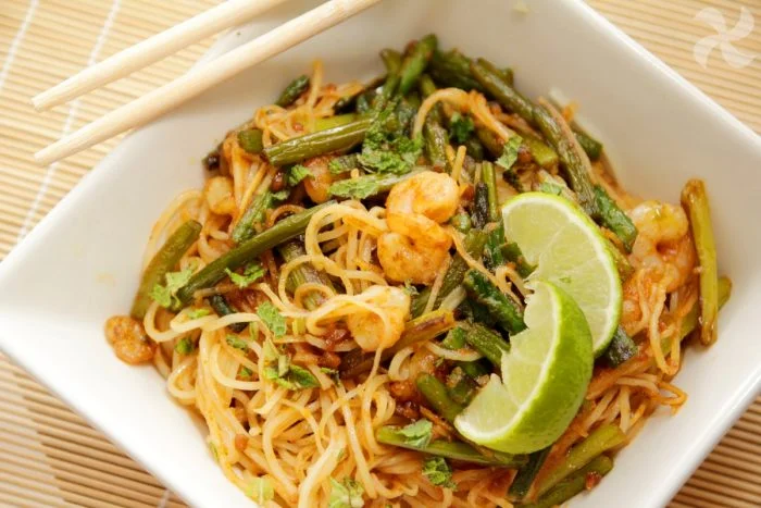 Noodles con espárragos, gambas con salsa de curry y cacahuetes