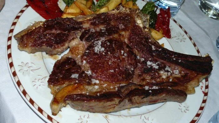 Chuletón de ternera con salsa de tomate y alcachofas salteadas