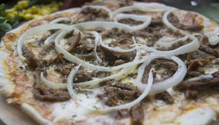 Pizza gourmet de jabalí con mozzarella y tomate fresco