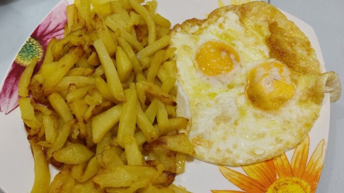 Patatas fritas con huevos en la freidora de aire