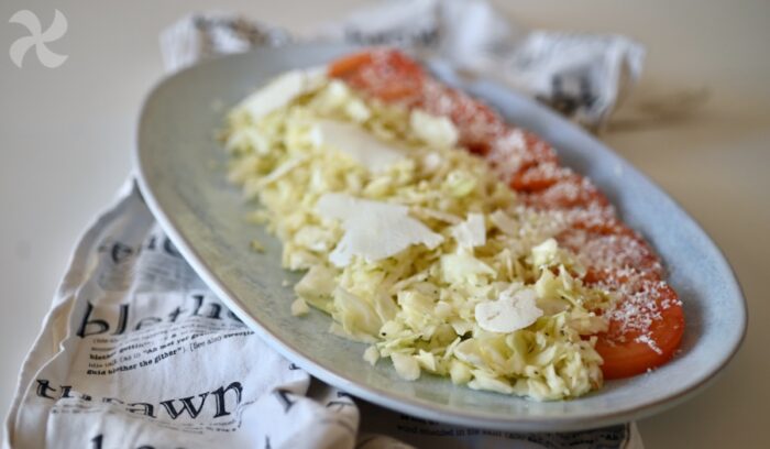 Ensalada de repollo y manzana con tomate y queso de oveja